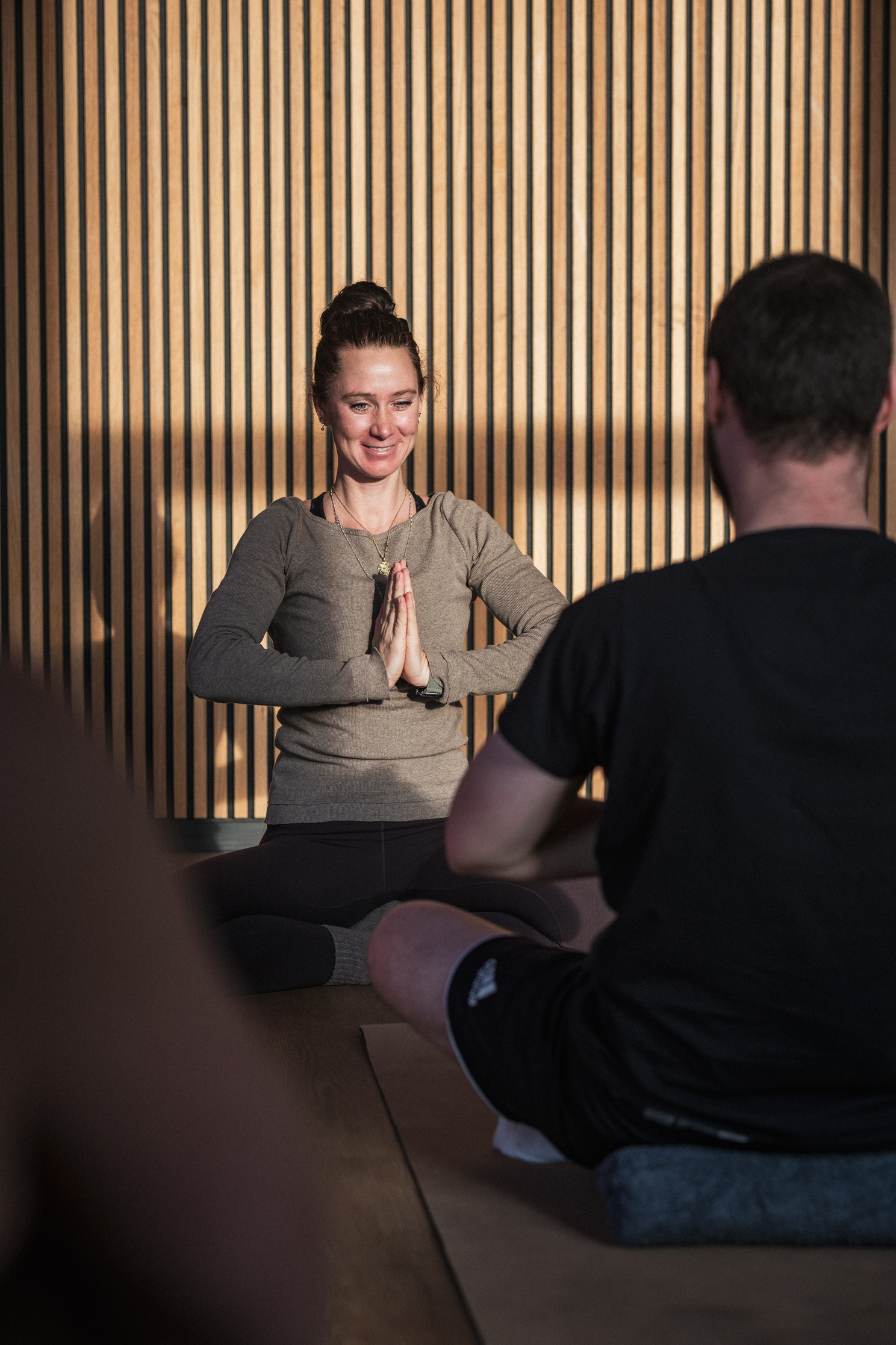 Ein Yogalehrerin leitet einen Yogakurs an.