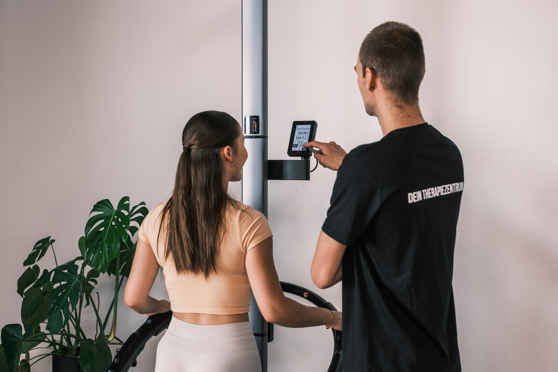 Ein Trainer macht eine Messung an einer Frau.