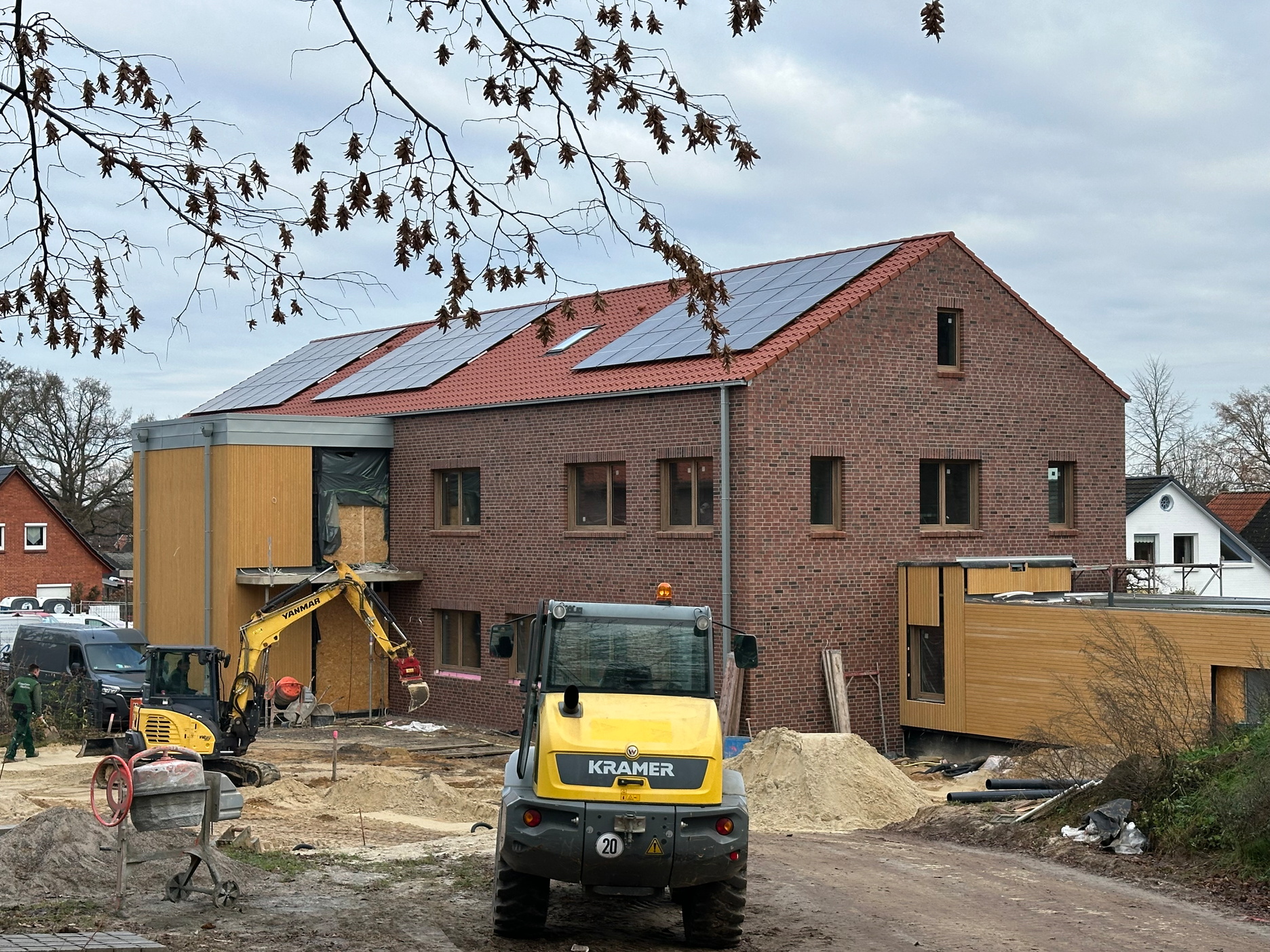 Baufortschritt eines Gebäudes im Rohbau, eingerüstet und bereit für den nächsten Schritt