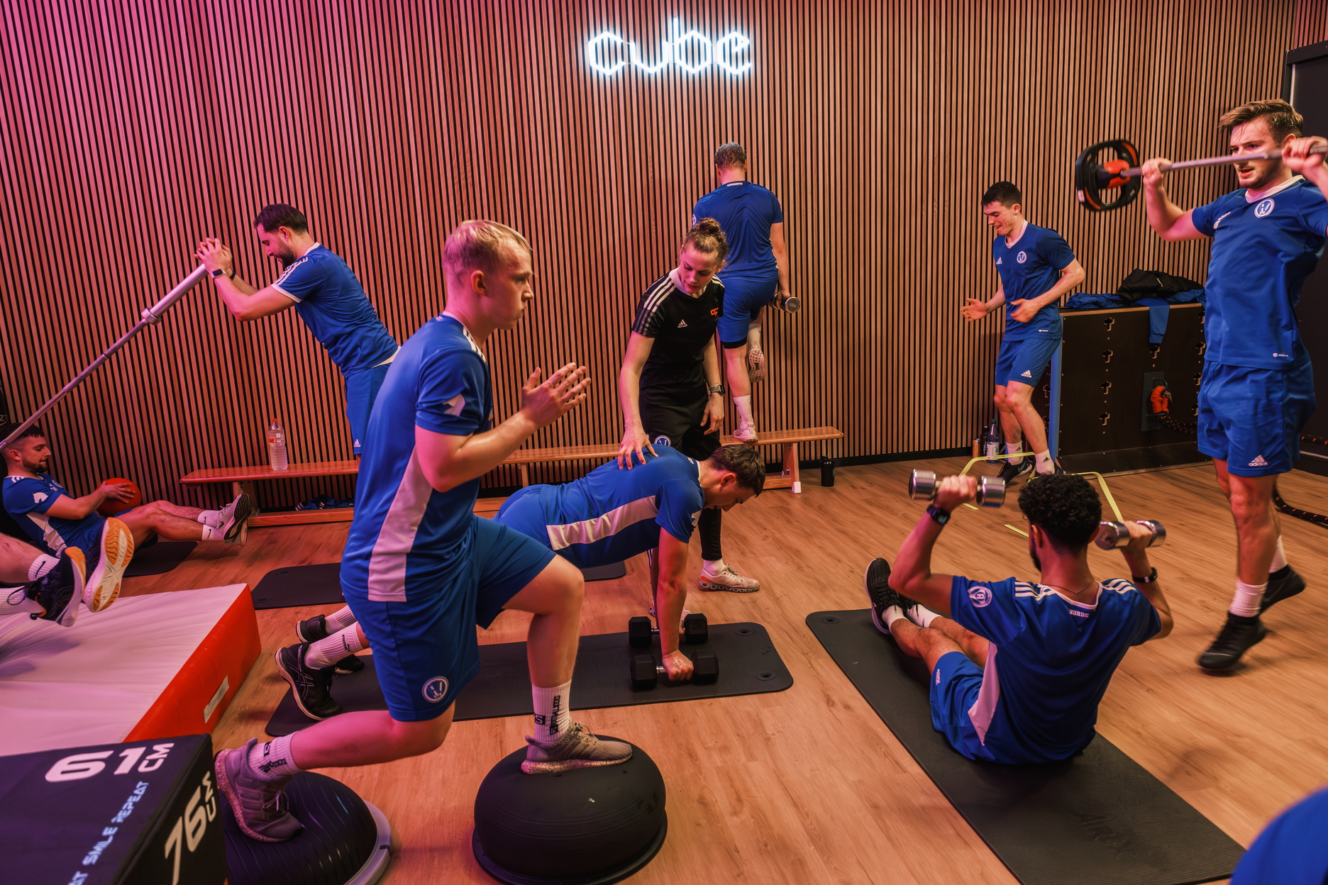 Eine Fußsballmannschaft macht verschiedene Übungen in einem Trainingsraum
