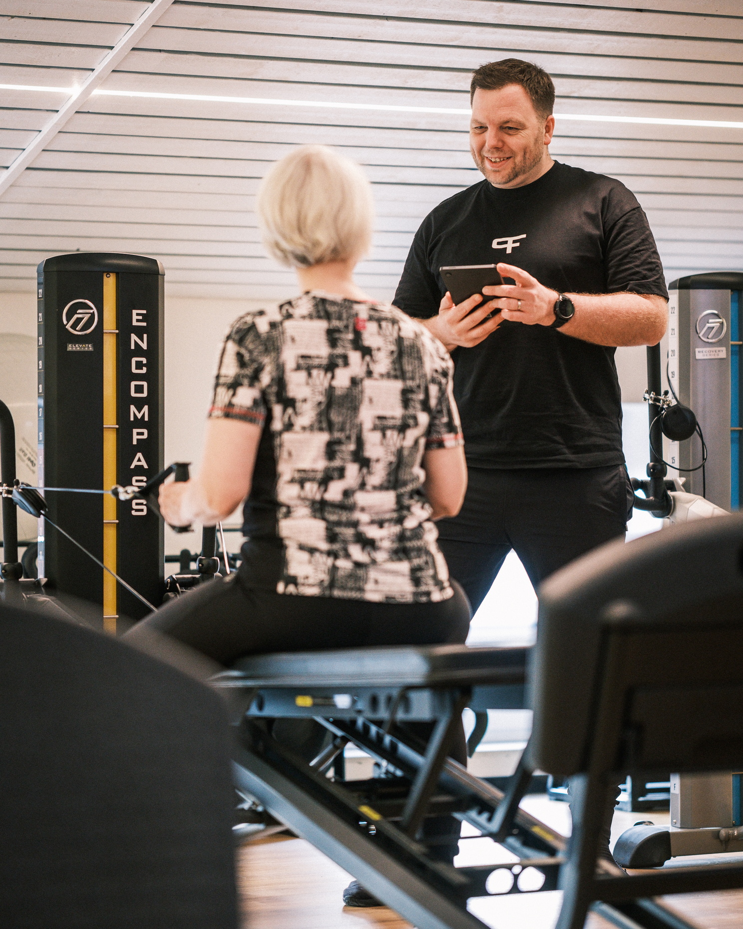 Ein Therapeut leitet eine Übung einer Patientin an einem Sportgerät an.