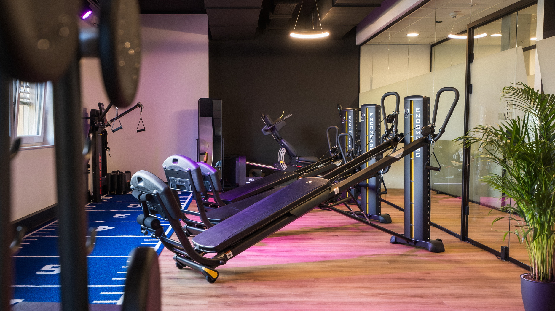 Trainingsraum mit modernen Fitnessgeräten, Glasfront und Sprintbahn