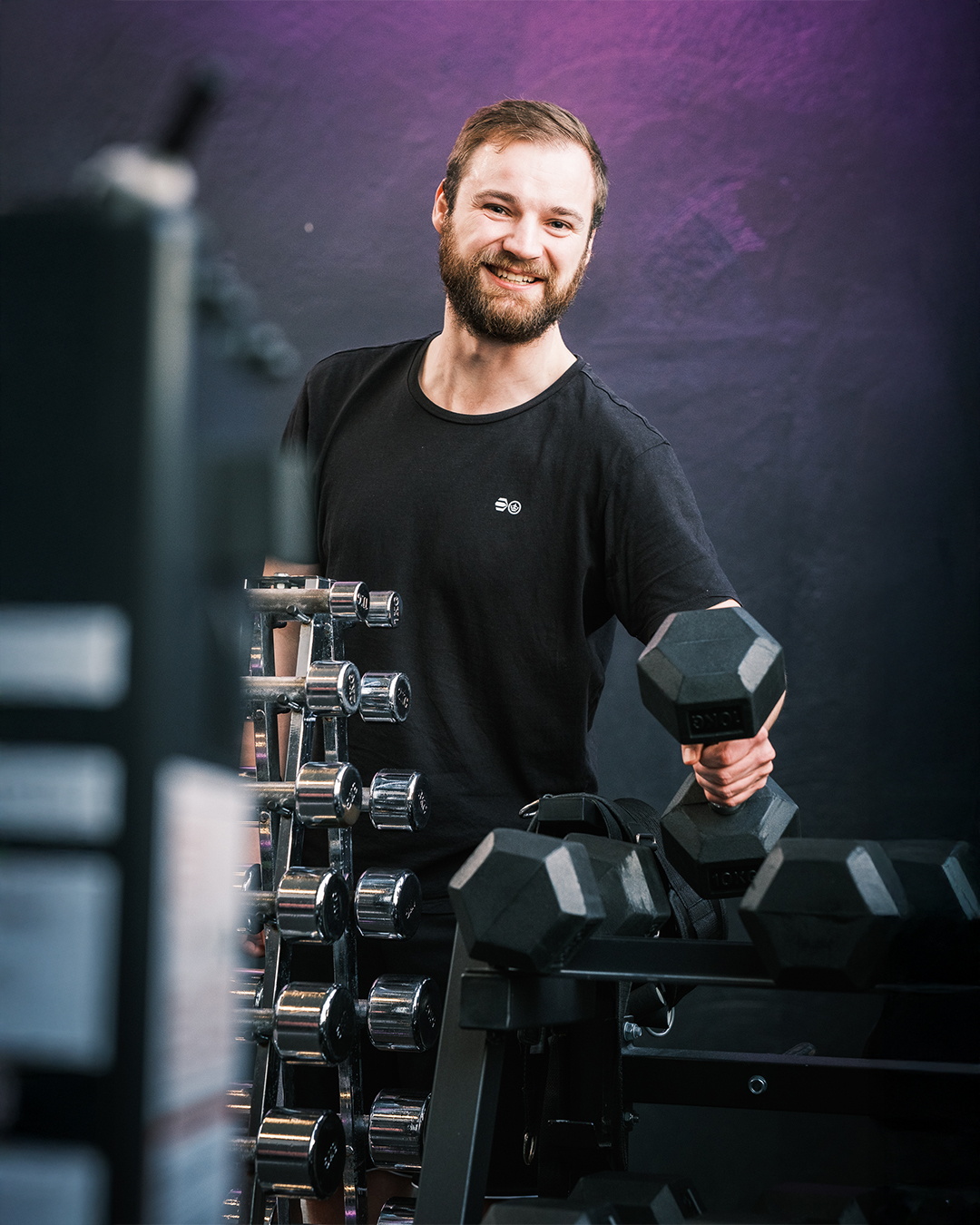Ein Mann nimmt im Trainingsraum ein Gewicht hoch.