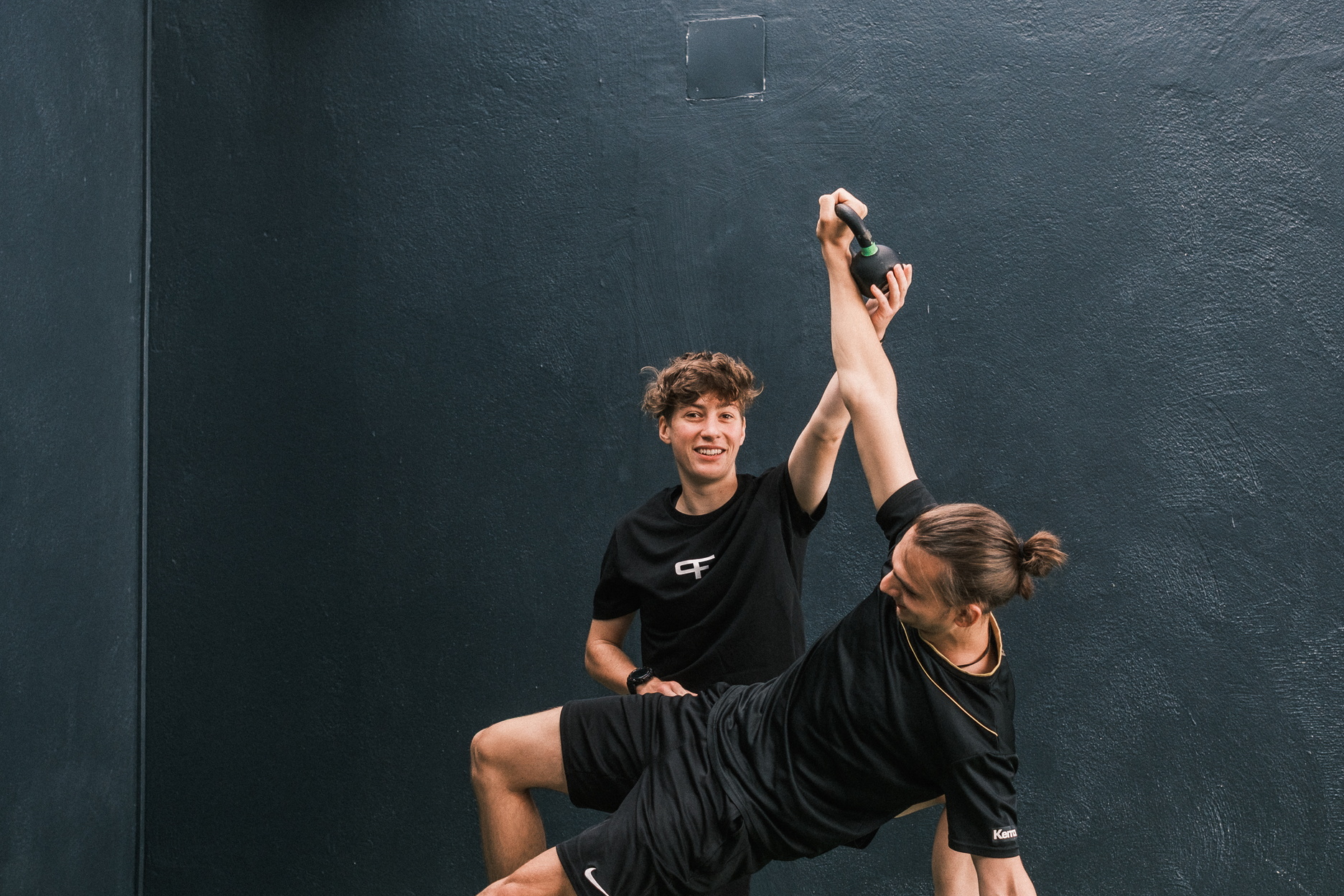 Eine Trainierin leitet einen Trainierenden an.