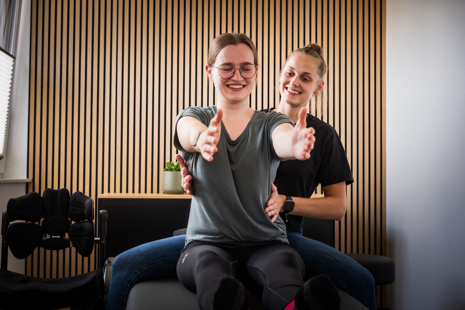 Ein Physiotherapeutin behandelt eine Patientin auf einer Liege.