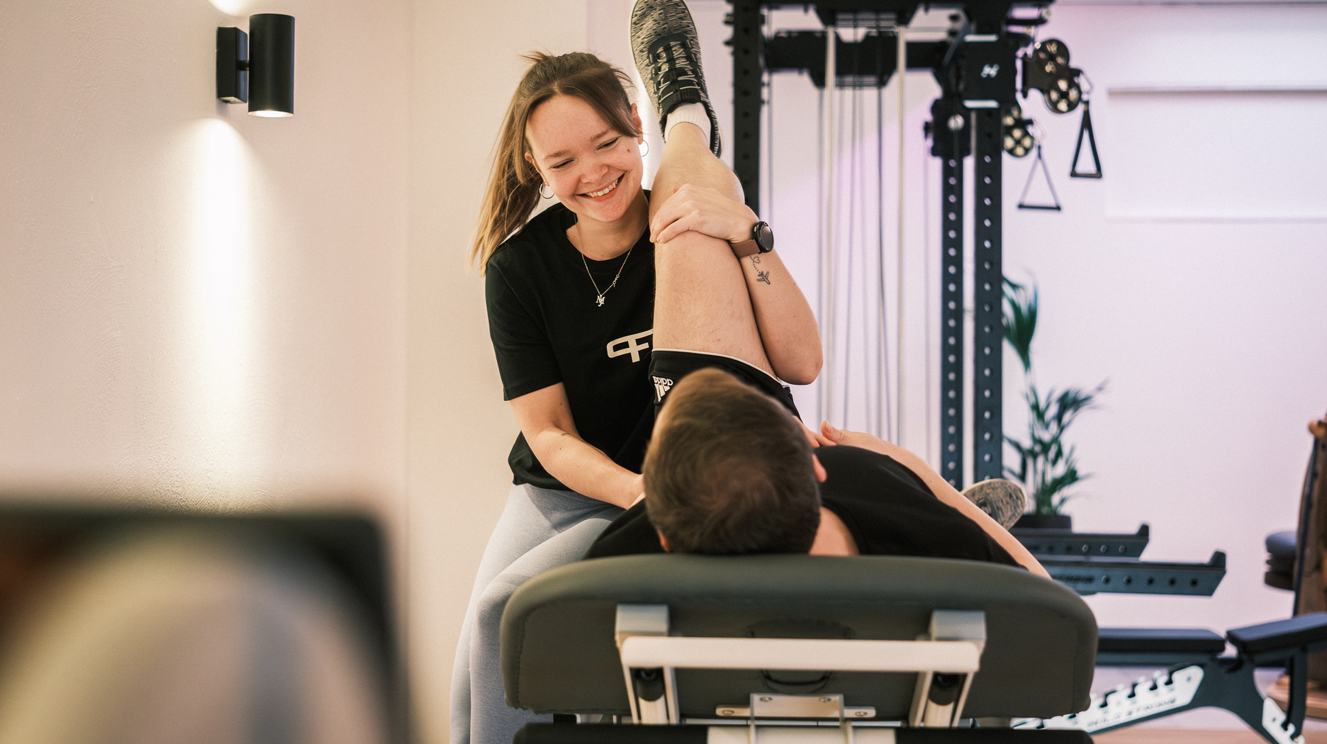 Ein Therapeutin behandelt einen Patienten auf einer Liege.