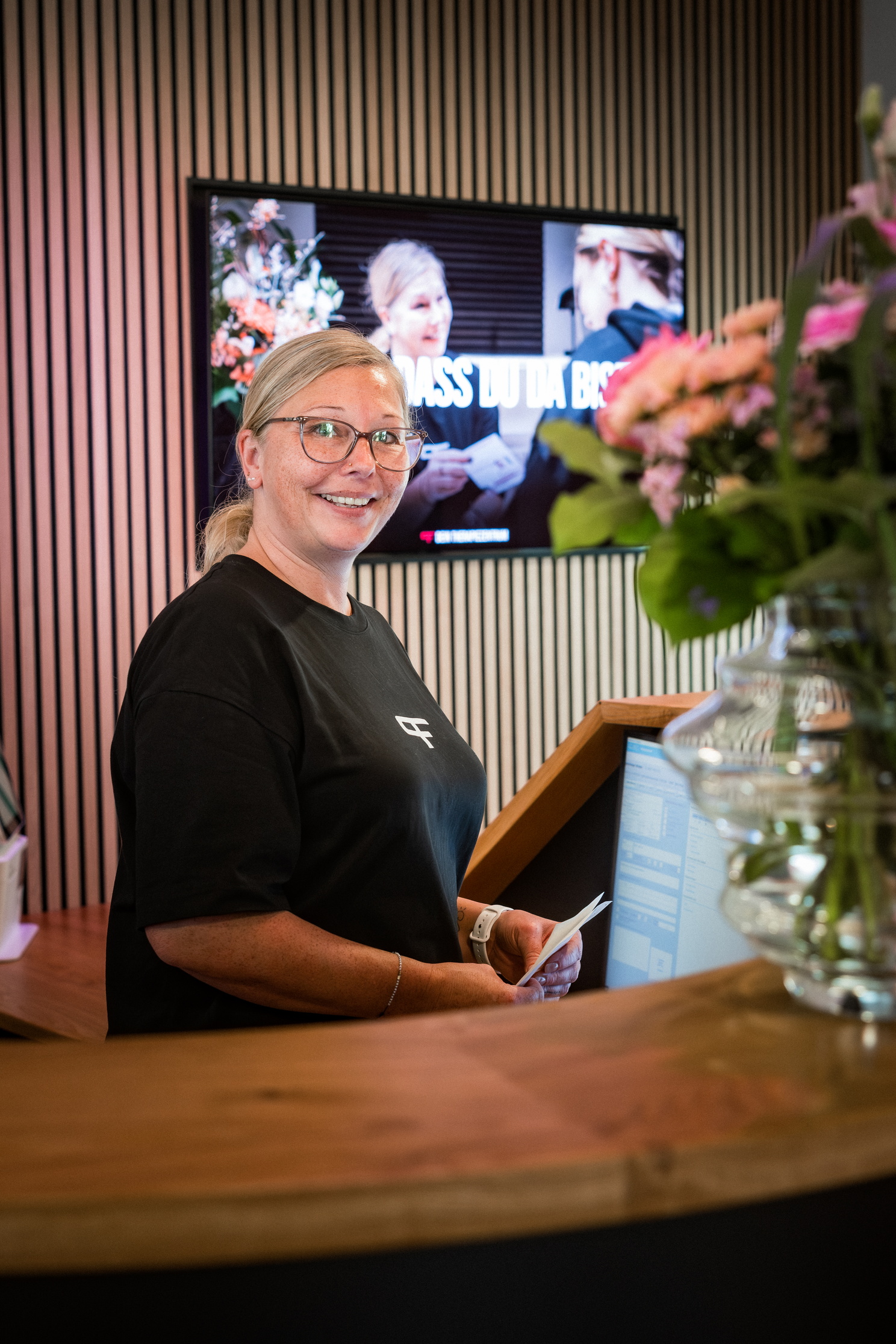 Eine freundliche Frau am Empfang hinter dem Tresen.