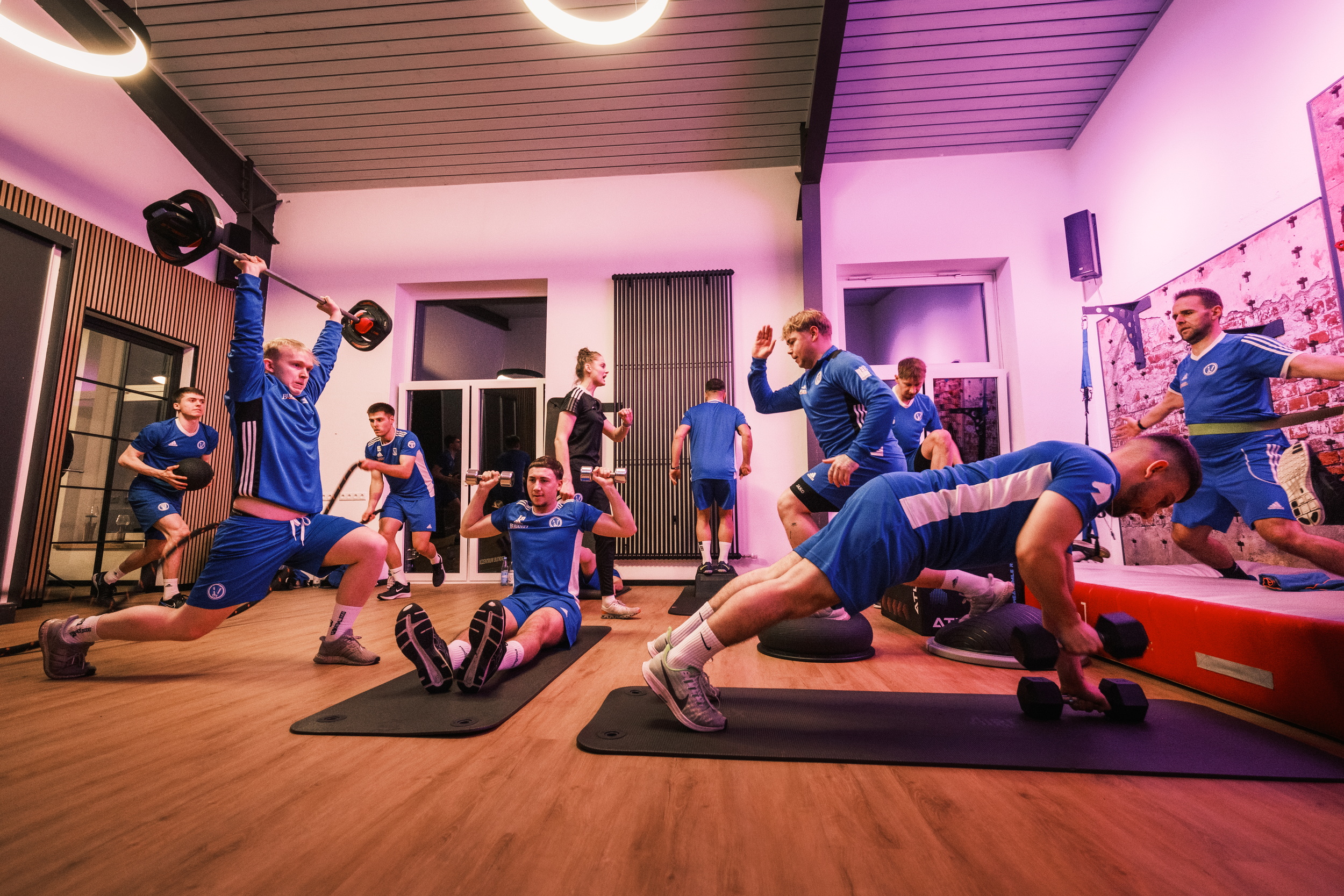 Ein Fußballteam macht Übungen in einem Sportraum.