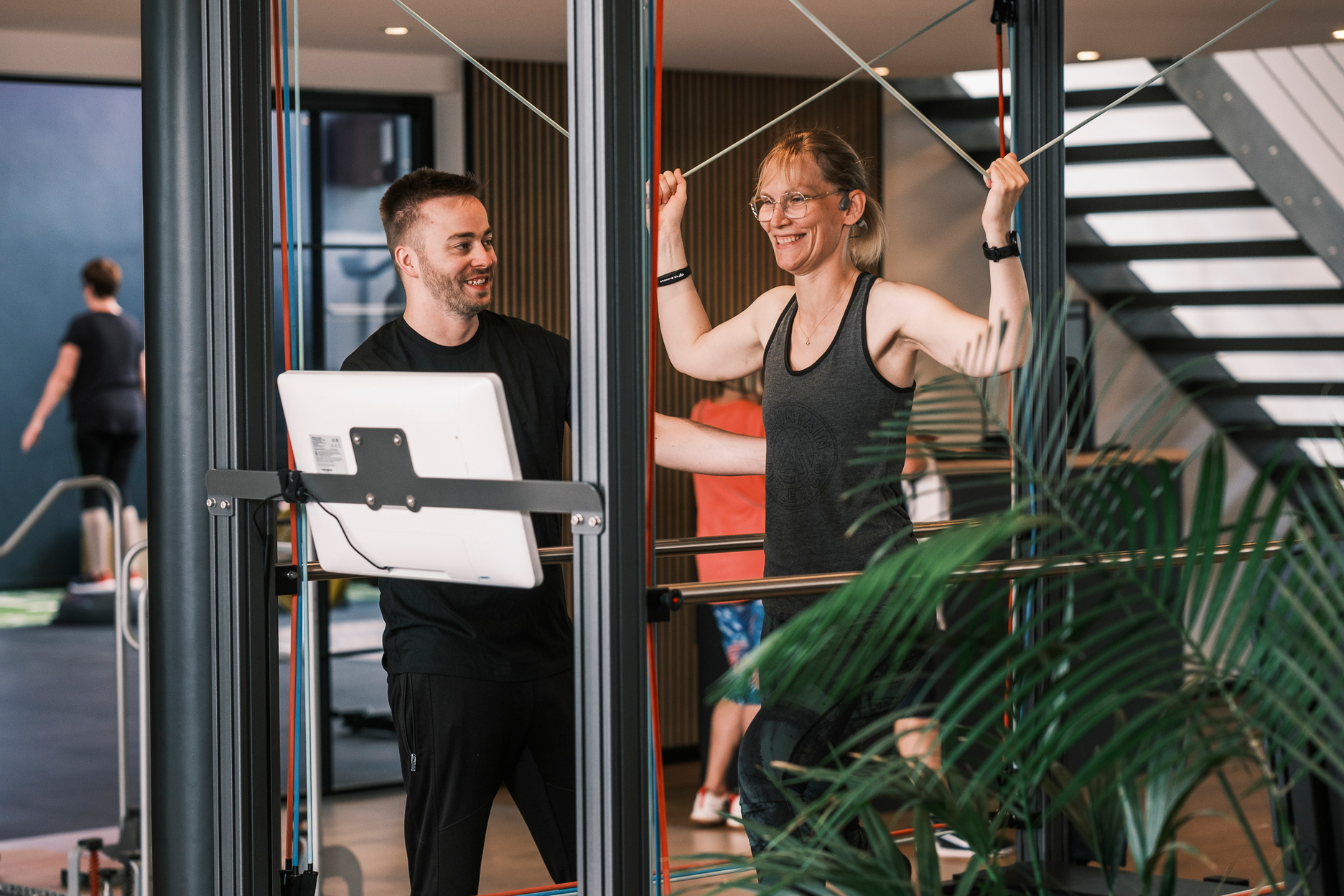 Ein Therapeut leitet seine Patienten bei Übungen auf dem Sensopro an.